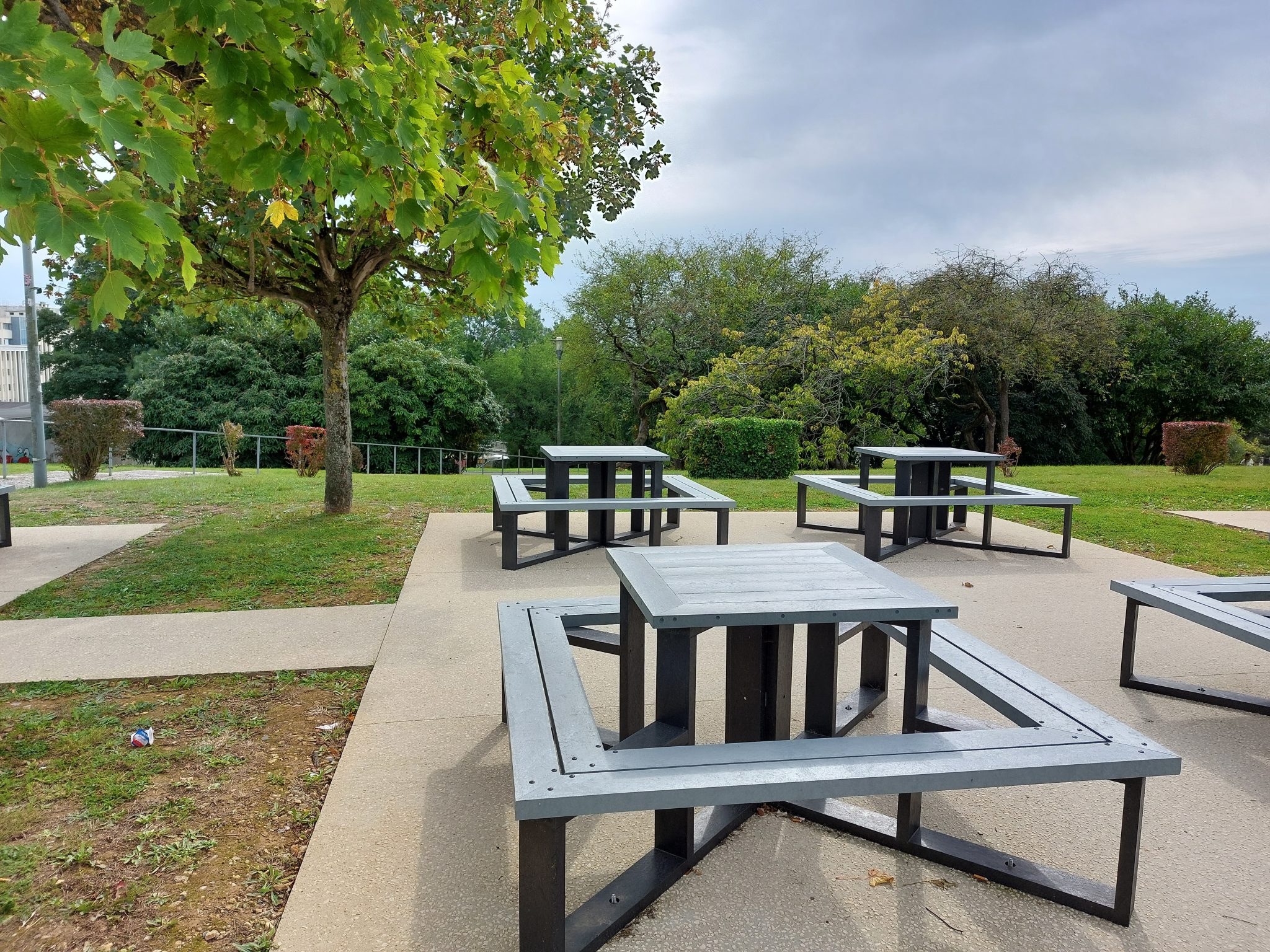 Parc avec tables de pique-nique en bois.