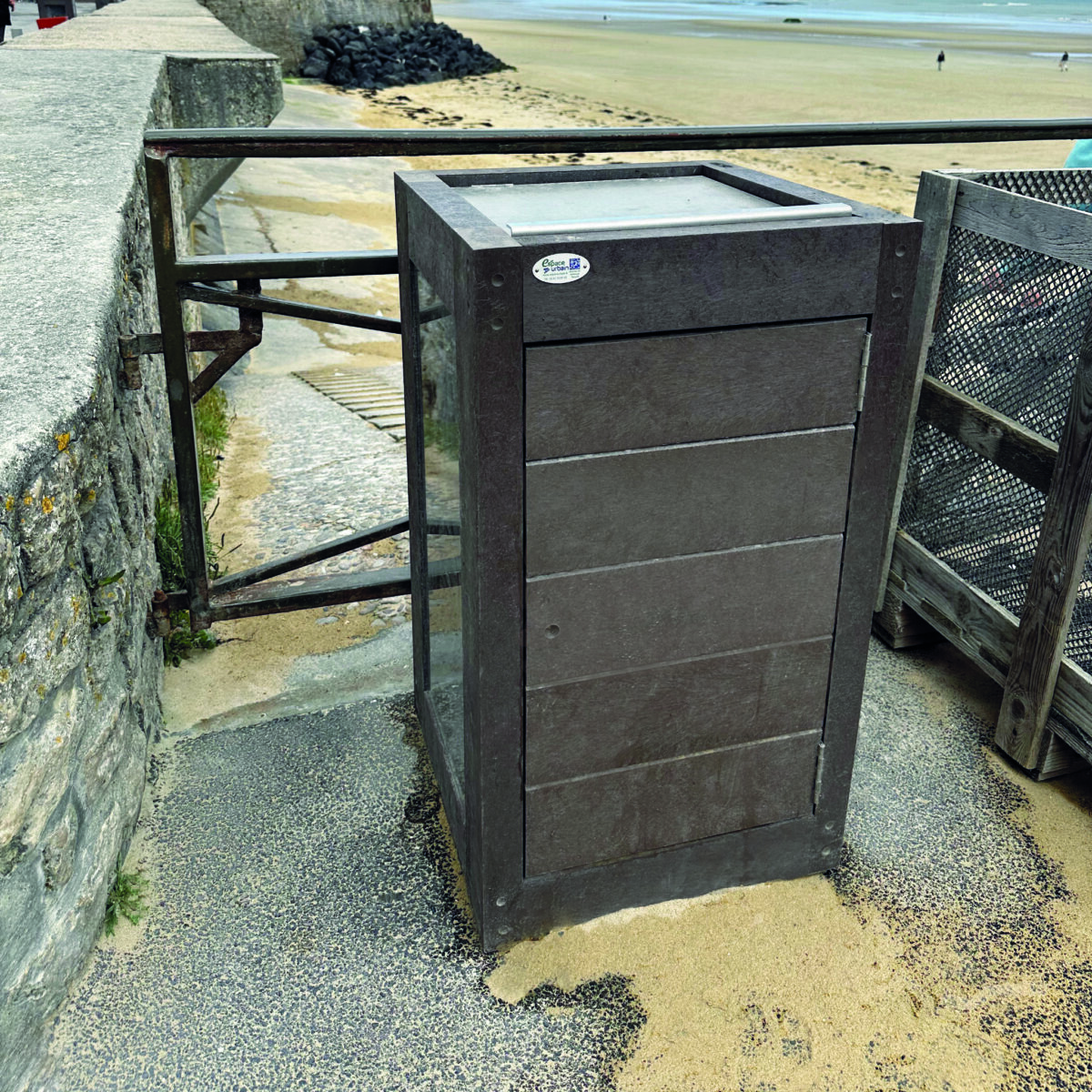 Poubelle marron près de la plage et promenade.